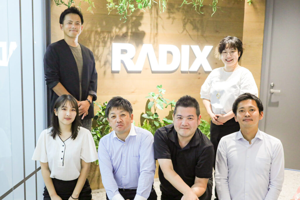 前列右からRADIX・CG株式会社 システム推進課　係長 濱田竜也さん、ビジネスサポート課 外国人支援担当鶴岡洋介さん、システム推進課 課長 宇高叔央さん、同課 登坂美月さん
株式会社マスドライバー代表 牧野徹郎（後列左）、リードディレクター 甘粕亜由美（後列右）